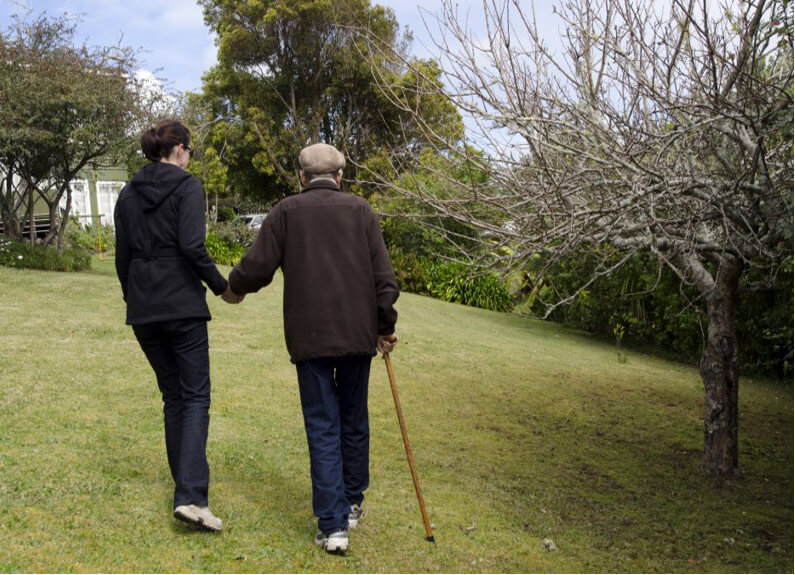  A caregiver accompanies a person with mobility problems 